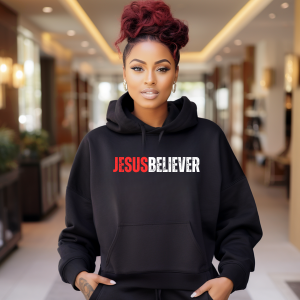 Person wearing a black hoodie with 'JESUS BELIEVER' text in a modern indoor setting